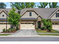 Charming townhome with stone and brick accents, well-manicured landscaping, and attached two-car garage at 192 Glenpark Pl, Cary, NC 27511