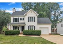 Charming two-story home with a manicured lawn, black shutters, and an attached garage at 201 Crossfire Rd, Holly Springs, NC 27540