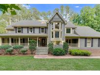 Charming two-story home with a bay window, landscaped yard, and covered porch with a stone walkway to the front door at 201 Village Dr, Knightdale, NC 27545