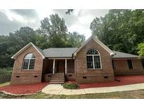 Charming brick home featuring arched windows and a cozy front porch at 2032 Sherry Lynn Dr, Garner, NC 27529