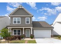 Attractive two-story home with an attached garage, covered porch and well-maintained landscaping at 34 Tanglewood Pl, Angier, NC 27501