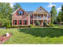 Traditional brick home featuring red shutters, a spacious front lawn, and an inviting two-story entrance at 3404 Mount Pisgah Way, Cary, NC 27519