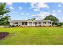Charming single story home featuring a beautiful front lawn, mature landscaping and inviting front porch at 360 Country Way, Sanford, NC 27332