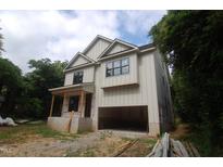 Two-story home with light siding and black trim, featuring an attached garage and covered entry at 4109 Stonewall Dr, Raleigh, NC 27604