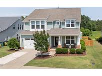 Charming two-story home features a manicured lawn, inviting front porch, and attached two-car garage at 42 Village Walk Dr, Chapel Hill, NC 27517