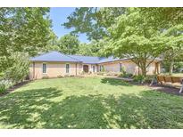 Charming brick home featuring a manicured lawn and mature trees providing ample shade at 423 N Cameron St, Hillsborough, NC 27278