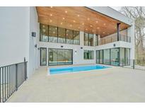 Expansive outdoor pool area featuring sleek design, large windows, and a wood-paneled ceiling at 4908 Birchleaf Dr, Raleigh, NC 27606
