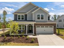 Charming two-story home featuring a brick and siding facade, and a two-car garage at 601 Lauren Ann Dr, Apex, NC 27523