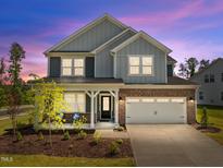 Charming two-story home with brick and siding, manicured lawn, and attached two car garage at 601 Lauren Ann Dr, Apex, NC 27523