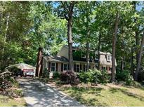 Charming two-story home featuring red shutters, lush landscaping and a detached garage at 702 Longleaf Dr, Chapel Hill, NC 27517