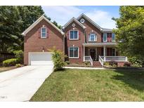 Charming two-story brick home with a well-manicured lawn and inviting front porch at 708 Cheselden Dr, Durham, NC 27713