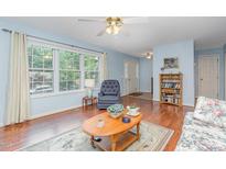 Bright living room with large window, hardwood floors, and floral sofa at 790 Cashmere Ct, Sanford, NC 27332