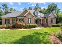 Beautiful brick home featuring a well-manicured lawn, mature trees, and a welcoming entrance at 7932 Twin Pines Way, Fuquay Varina, NC 27526