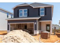 New two-story home under construction shows siding, garage and front door with building materials in the foreground at 845 Ottawa Dr, Garner, NC 27529