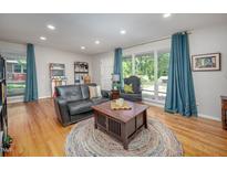 Inviting living room featuring hardwood floors, a black leather sofa, and plenty of natural light at 903 W Maynard Ave, Durham, NC 27704