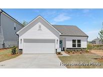 Charming single-story home with a white exterior, attached garage, and manicured front lawn at 94 Mable Court # 16, Lillington, NC 27546