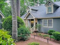 Charming home exterior with dormer windows, landscaped front yard, and a brick pathway leading to the front door at 107 Long Shadow Ln, Cary, NC 27518