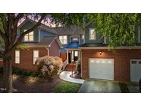 Charming two-story exterior with brick accents, lush landscaping, and a welcoming two-car garage at 11013 Louson Pl, Raleigh, NC 27614