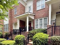 Charming red brick townhome with black iron railings and a welcoming covered front porch at 111 Finsbury Street St, Durham, NC 27703