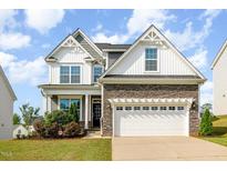 Beautiful two-story home featuring stone accents, a two-car garage, and manicured landscaping at 111 Laporte Path, Garner, NC 27529