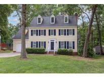 Charming two-story home with dormer windows, blue shutters, and well-manicured landscaping at 1113 Smokewood Dr, Apex, NC 27502