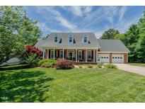 Charming brick home featuring a well-manicured lawn, a two-car garage and a welcoming covered front porch at 114 Fieldstone Dr, Burlington, NC 27215