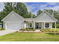 Charming single-story home featuring a pristine front yard and an attached garage with a lovely front porch at 1304 Essex Skipper Way, Fuquay Varina, NC 27526