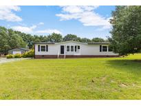 Charming one-story home with white siding, brick accents, and a spacious green lawn at 165 Dawn Rd, Benson, NC 27504