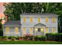 Charming two-story home with classic architecture, covered front porch and colorful flowering plants at 2107 Somers Ave, Burlington, NC 27215