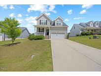 Charming two-story home with a manicured front yard and a two-car garage at 225 Alcock Ln, Youngsville, NC 27596