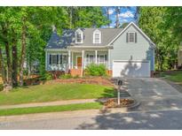 Charming home featuring a two-car garage, a manicured lawn, and mature trees in a desirable neighborhood at 2408 Fordcrest Dr, Apex, NC 27502