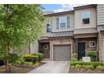 Charming townhome with stone accents, neutral siding, well maintained landscaping and a one-car garage at 256 Rubrum Dr, Hillsborough, NC 27278