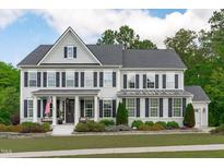 Beautiful two-story home with a manicured lawn and charming curb appeal, complemented by black shutters and a welcoming porch at 2711 Jordan Pointe Blvd, New Hill, NC 27562