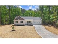 Charming single-Gathering home featuring a spacious two-car garage and a long concrete driveway at 295 Rudd Rd, Youngsville, NC 27596