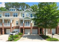 Charming townhome featuring a brick facade, attached garage, and second-story balcony at 3034 Winfred Dell Ln, Cary, NC 27511