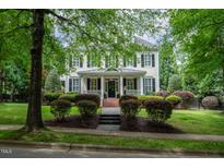 Charming two-story home with black shutters, brick front steps, and professionally landscaped yard at 3325 Falls River Ave, Raleigh, NC 27614
