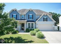 Charming two-story home with a manicured lawn, blue siding, black shutters, and a two-car garage at 3536 Greenville Loop Rd, Wake Forest, NC 27587