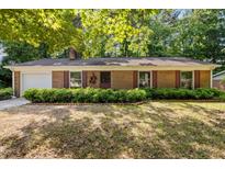 Charming brick home featuring manicured front yard with lush green hedges and brick-lined flowerbeds at 4119 Toroella St, Durham, NC 27704