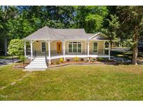 Charming single-story home featuring a welcoming front porch and landscaped garden, surrounded by mature trees at 4220 Hope Valley Road Rd, Durham, NC 27707