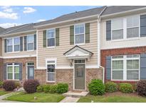 Inviting townhouse with neutral siding, brick accents, manicured bushes and contrasting shutters at 510 Berry Chase Way, Cary, NC 27519