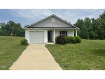 Charming single-story home with attached garage and well-maintained front lawn at 5219 Merlin Dr, Snow Camp, NC 27349