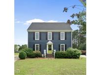 Charming two-story home with a manicured lawn, black shutters, and a bright green front door at 6 W Canterbury Ct, Wendell, NC 27591