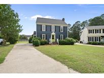 Charming two-story home with a lush green lawn, a driveway, and a vibrant lime green front door at 6 W Canterbury Ct, Wendell, NC 27591