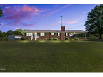 Charming single-story brick home featuring a spacious front lawn and a covered carport at 6080 Us 421 N, Lillington, NC 27546