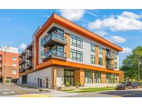 Modern condo building with balconies and a colorful exterior design on a sunny day at 615 Daniels St # 215, Raleigh, NC 27605