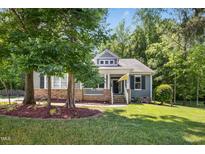 Charming home with a welcoming front porch, lovely landscaping, and a well-maintained lawn at 619 E Hatterleigh Ave, Hillsborough, NC 27278