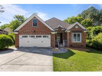Charming red brick home with a two-car garage and a well-manicured lawn at 624 Powhatan Dr, Fuquay Varina, NC 27526