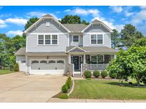 Charming two-story home featuring a manicured lawn, two car garage, and inviting front porch at 85 Clubhouse Dr, Youngsville, NC 27596