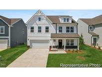 Charming two-story home with white siding, a two-car garage, and a well-manicured lawn at 88 Mable Court # 17, Lillington, NC 27546