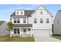 Charming two-story home boasts a crisp white facade, an attached two-car garage, and beautifully manicured lawn at 88 Mable Court # 17, Lillington, NC 27546